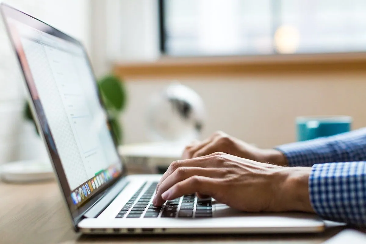 Personne rédigeant du contenu sur un ordinateur portable