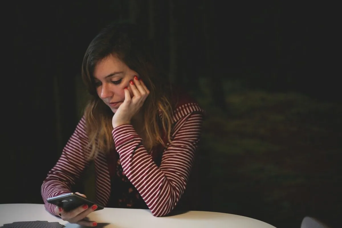 Personne consultant son téléphone d'un air hésitant